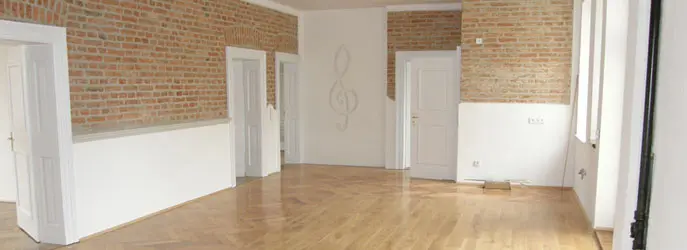 Leere Wohnung mit Parkett und Sichtmauerwerk